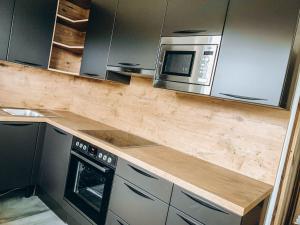 a kitchen with a wooden counter top and a microwave at FOUR PEAKS Apartment in Flachau