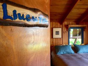 um sinal na parede de uma cabine com uma cama em Hostel Raíz em Pucón