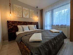 a bedroom with a large bed with two towels on it at Borovets Gardens B30 Morunov Apart in Borovets