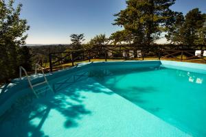 una gran piscina azul con un puente de madera en Hotel Panorama en La Cumbrecita