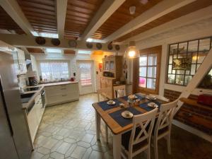 a kitchen with a table and chairs in a room at Lindenhuus-Urlaub unter einem Teilreetdach-Terrasse - Nahe Norden-Norddeich in Osteel