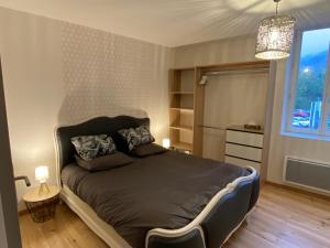 - une chambre avec un lit et un lustre dans l'établissement Cahors 62m2 - T3 neuf 4 étoiles certifié catégorie Prestige - le Bartassec - wifi - parking, à Cahors