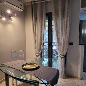 comedor con mesa de cristal y ventana en Chic & Relax apartment en Rímini