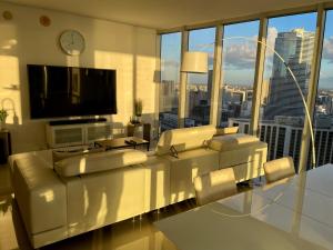 sala de estar con sofá y TV de pantalla plana en IconBrickell Tower 3 W Residences, en Miami