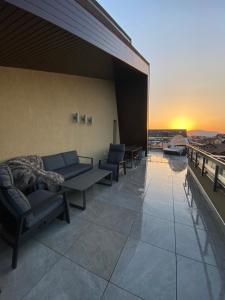 a balcony with couches and a sunset on a building at Art'penthouse in Braşov