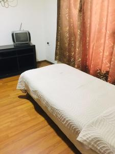 a bed in a room with a tv on a table at alquiler apto. para Brasileros cerca del estadio Centenario, para Conmebol in Montevideo