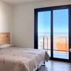 1 dormitorio con cama y vistas al océano en Edificio Vista a 50 metros del mar a estrenar en Mar del Plata