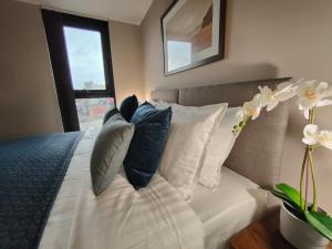 a bed with black and white pillows and a window at Luxury City Centre 2 bedroom apartment in Sheffield