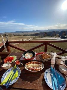 a picnic table with food on a wooden table at Etno selo Smrčevo brdo in Žabljak