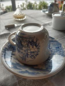 a blue and white cup on a plate on a table at Pousada Flor do deserto - Mandacaru in Santo Amaro