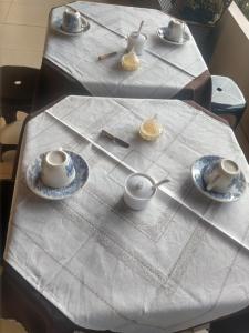 Deux tables avec des tasses à thé et des soucoupes sur elles dans l'établissement Pousada Flor do deserto - Mandacaru, à Santo Amaro