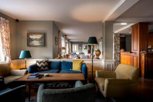 a living room with a blue couch and chairs at Boutique Hotel Bellevue Lermoos in Lermoos