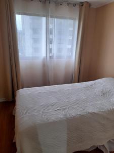 - une chambre avec un lit blanc et une fenêtre dans l'établissement Departamento Temuco Thiers, à Temuco