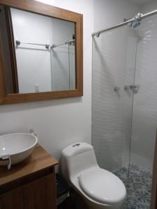 y baño con aseo, lavabo y ducha. en Apartamento vacacional FL Martinz, en Manizales