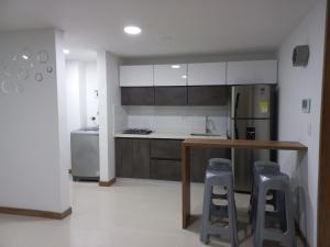 a kitchen with a counter and two bar stools at Apartamento vacacional FL Martinz in Manizales