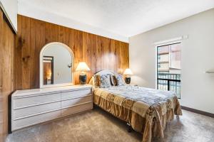 a bedroom with a bed and a mirror at Sand & Sea: The Bilberry (114) in Seaside