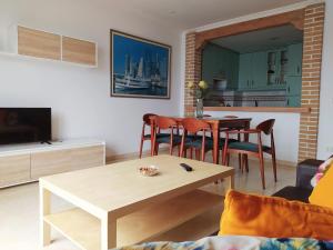 salon ze stołem i krzesłami oraz kuchnię w obiekcie Precioso ático con vistas a pie de playa w mieście Sanxenxo