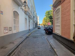 una calle vacía con motocicletas estacionadas al lado de los edificios en Estudio Alameda, en Cádiz
