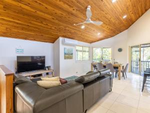 a living room with a large couch and a television at The Birubi Beach House 11 Campbell Ave Close to the beach pet friendly holiday home in Anna Bay