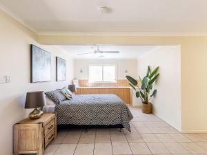 a bedroom with a bed and a table and a window at The Birubi Beach House 11 Campbell Ave Close to the beach pet friendly holiday home in Anna Bay