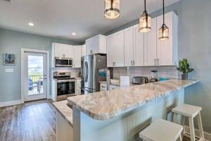 a kitchen with white cabinets and a large marble counter top at Newly Built DAUPHIN ISLAND Home! in Dauphin Island