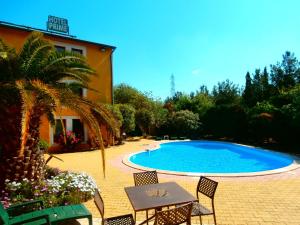 una piscina con sedie e un tavolo di fronte a un edificio di Cit'Hotel Hotel Prime - A709 a Saint-Jean-de-Védas