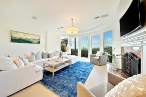 un soggiorno con mobili bianchi e un tappeto blu di Spacious Tropical Paradise a San Diego