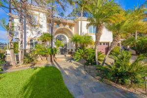 ein großes Haus mit Palmen und Gehweg in der Unterkunft Spacious Tropical Paradise in San Diego