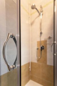 een badkamer met een douche en een glazen deur bij CASA MARGHERITA in Pisa