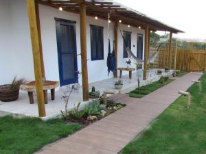 a house with a patio with a bench and a table at Aldeia Corumbau in Corumbau