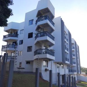ein weißes Gebäude mit Balkon auf der Seite in der Unterkunft Apartamento foz centro 03 in Foz do Iguaçu