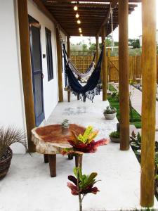 a hammock on the porch of a house at Aldeia Corumbau in Corumbau
