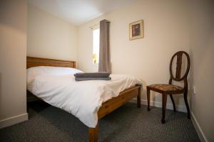 a bedroom with a bed and a chair and a window at The Starry Rock in Kirriemuir