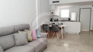Una sala de estar con un sofá y una cocina. en Playa Negra View, en Puerto de Santiago
