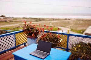 a laptop sitting on a blue table on a balcony at dar boujdaa in Sidi Kaouki