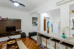 cocina con paredes blancas y encimera con taburetes en Copa Apartments, en Río de Janeiro