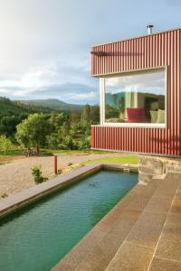 a swimming pool in front of a house at Encosta do Sobreiro - Serra da Estrela in Fornos de Algodres