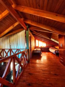 an attic room with two beds and a wooden floor at Las Retamas in Villa Pehuenia
