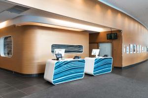 a lobby with two tables with blue and white at Radisson Blu Hotel, Trondheim Airport in Stjoerdal