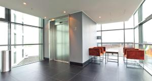 a room with a table and chairs and windows at Radisson Blu Hotel, Trondheim Airport in Stjoerdal