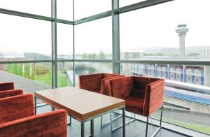 een tafel en stoelen in een kamer met ramen bij Radisson Blu Hotel, Trondheim Airport in Stjoerdal