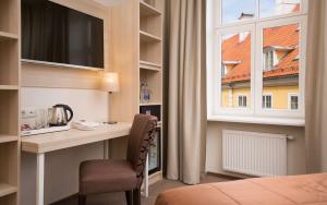 um quarto de hotel com uma secretária e uma janela em Radisson Hotel Old Town Riga em Riga