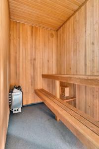 un sauna en bois avec un banc et une glacière dans l'établissement Aiden by Best Western Trondheim Airport, à Stjoerdal