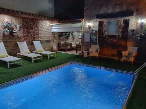 a large swimming pool with chairs and a table at Apartamentos Turísticos Tronca Luxury in Granada