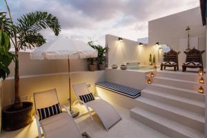 un patio con 2 sillas y una piscina en La Colonial Suites Apartamentos de Lujo en Las Palmas de Gran Canaria