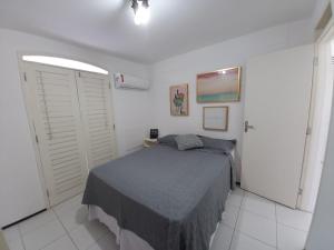 a bedroom with a bed in a white room at Casa condomínio 2 suítes in Juazeiro do Norte