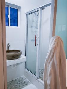 een badkamer met een douche, een toilet en een wastafel bij Sunsets At Tiffany's in Treasure Beach