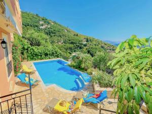 a swimming pool with chairs and a view of a mountain at Villa Eleni Kalami with private pool in Kalami