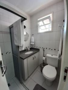 ein Bad mit einem WC, einem Waschbecken und einem Fenster in der Unterkunft Casa condomínio 2 suítes in Juazeiro do Norte