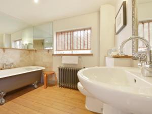 a bathroom with a tub and a toilet and a sink at Pittards Farm Cottage in Lambrook +11 photos